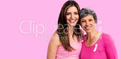 Composite image of smiling women in pink outfits posing for breast cancer awareness