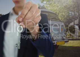 Businesswoman Hand  Holding key in front of camper van