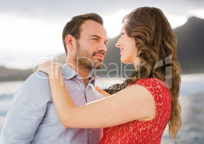 Couple dancing against blurry coastline