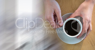 Overhead of hands with coffee cup and blurry white transition