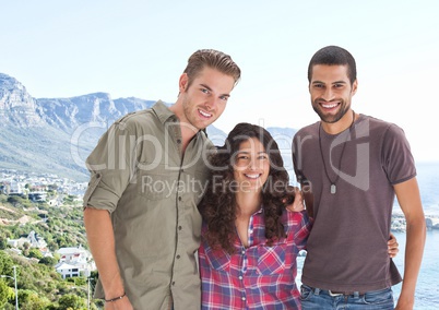 Friends posing against blurry coastline