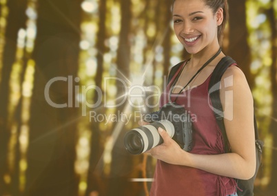 young happy photographer in the forest. With flares and bokeh overlap