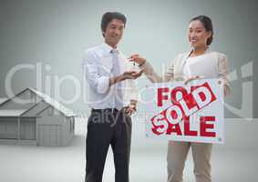 Man and woman with for sale sign and keys with house model in front of vignette