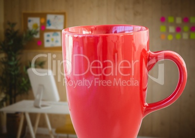 Red coffee cup against blurry office