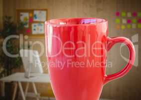 Red coffee cup against blurry office