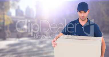 Delivery man with box against blurry street with flare