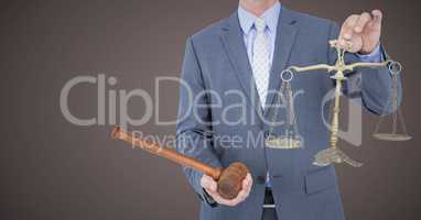 Male judge mid section with gavel and scales against brown background