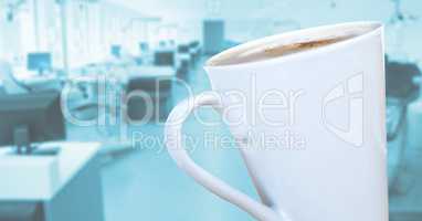 White coffee cup against blurry blue office