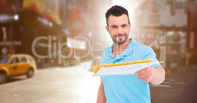 Delivery man handing out letters against blurry street with flare