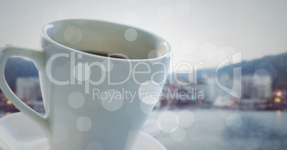 White coffee cup with bokeh against blurry skyline