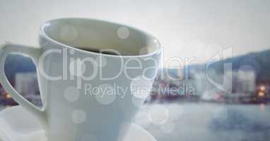 White coffee cup with bokeh against blurry skyline