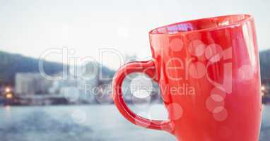 Red coffee cup with bokeh against blurry skyline