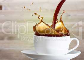 Coffee being poured into white cup against blurry wood panel