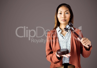 Female judge with gavel against brown background