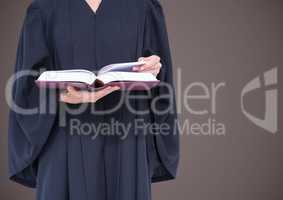 Female judge mid section with open book against brown background