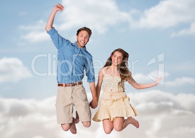 Couple jumping in air against blurry sky Couple jumping in air against blurry sky