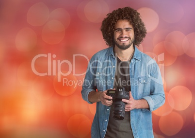 happy young photographer with camera on hands. Red bokeh background