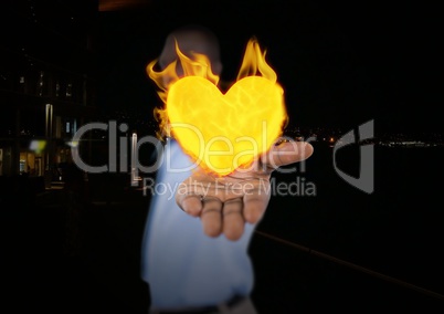 Man with hand spread of with heart fire icon over.  City at night