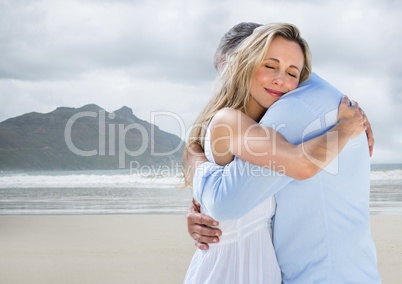 Couple hugging against blurry beach