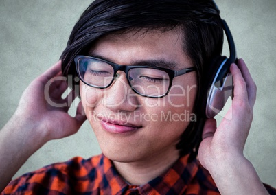 Close up of millennial man with headphones against light grey grunge wall