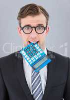 Nerd man with calculator in mouth against grey wall