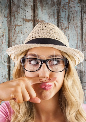 Millennial woman with mustache on finger against wood panel