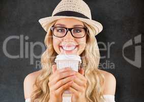 Close up of millennial woman smiling with coffee against grey grunge wall