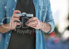 photographer hands with vintage camera ( foreground) in the city ( blurred lights)