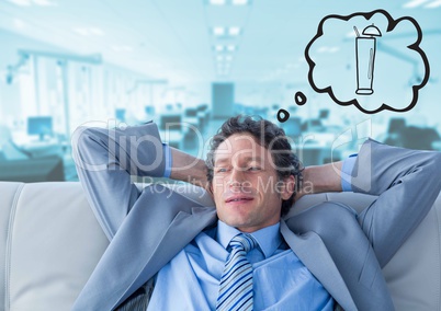 Business man on couch dreaming of cocktail against blurry blue office