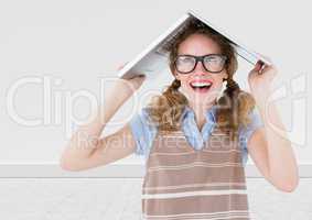 Nerd woman with laptop on head against white wall