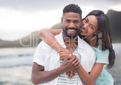 Couple embracing against blurry coastline