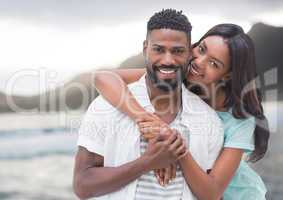 Couple embracing against blurry coastline