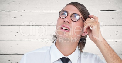 Close up of nerd man scratching head against white wood panel