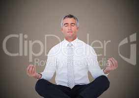 Business man meditating against brown background