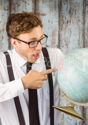 Nerd man pointing at globe against wood panel