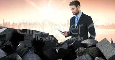 Brokenstone bricks pile and businessman on phone in cityscape