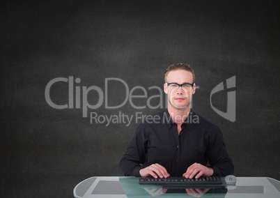 Nerd man at desk against grey wall