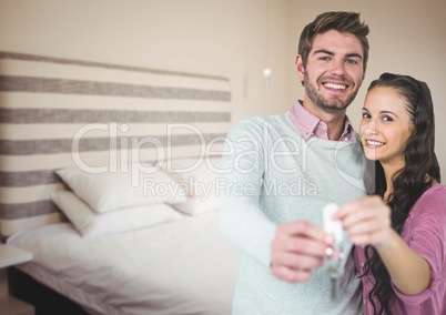 Couple Holding key in bedroom