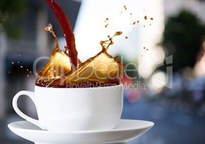 Coffee being poured into white cup against blurry street