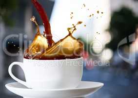 Coffee being poured into white cup against blurry street