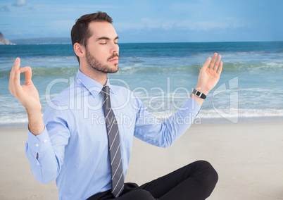 Business man meditating against beach