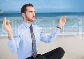 Business man meditating against beach