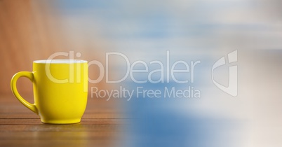 Yellow coffee cup with blurry sky transition