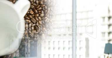 Overhead of white coffee cup with beans and blurry window transition