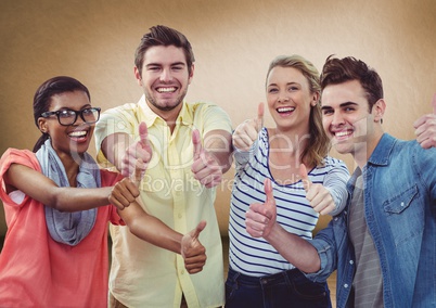 Millennial team giving thumbs up against brown background