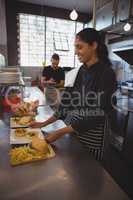 Waitress arranging plate with food in cafe
