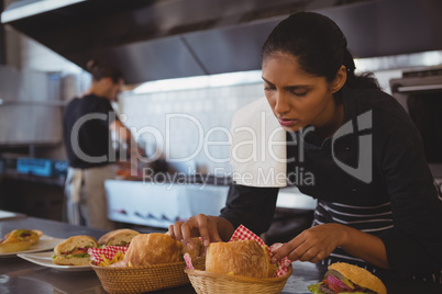 Waitress arranging baskets with food in cafe