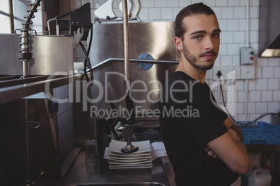 Portrait of waiter standing in kitchen