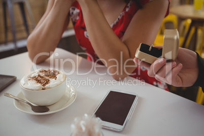 Cropped hand of man giving ring to girlfriend