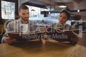 Friends reading menu at table